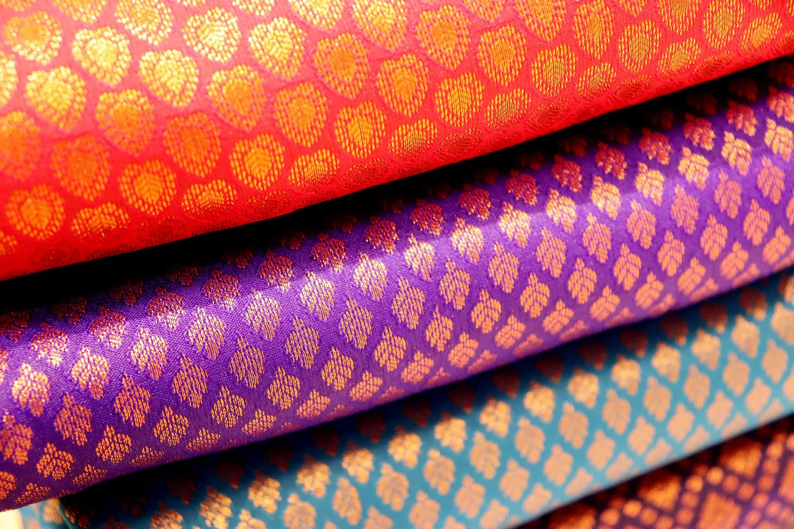 A richly coloured handwoven textile, folded and layered