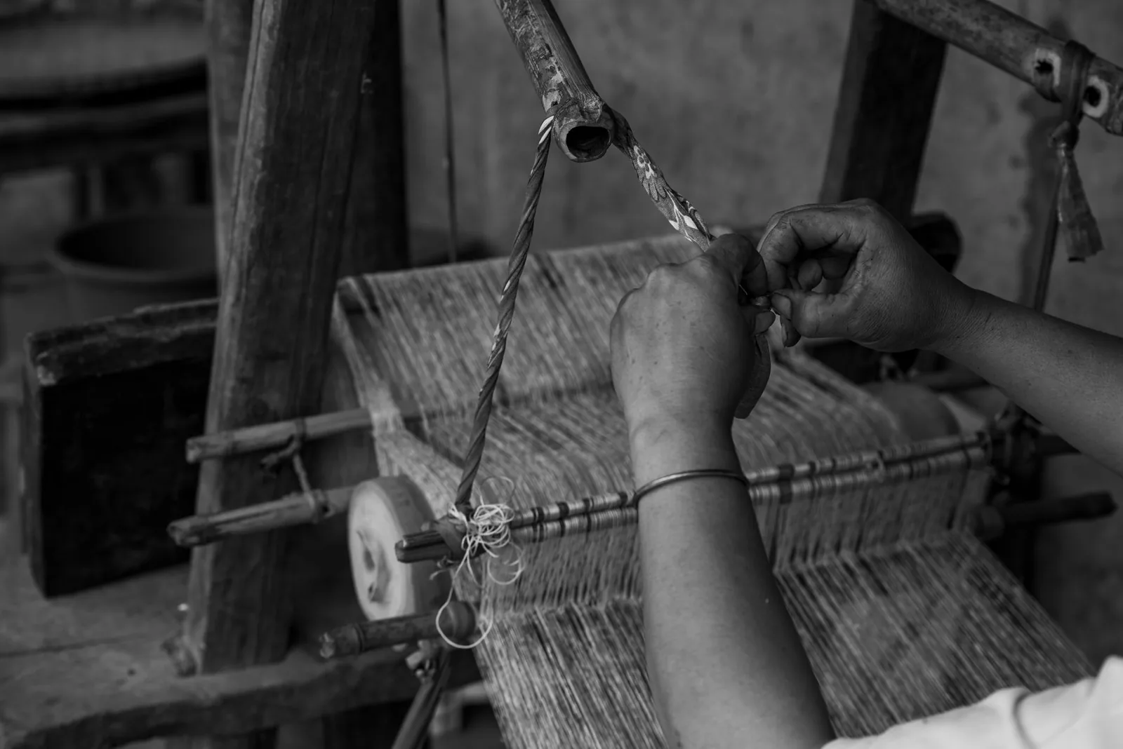 An artisan weaving fabric on a traditional handloom